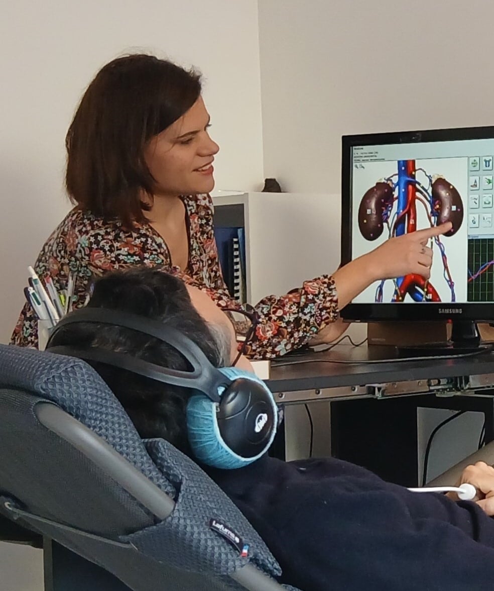 Séance de biorésonance avec analyse fréquentielle à l’écran, personne portant un casque et capteur pour le soutien global du corps.